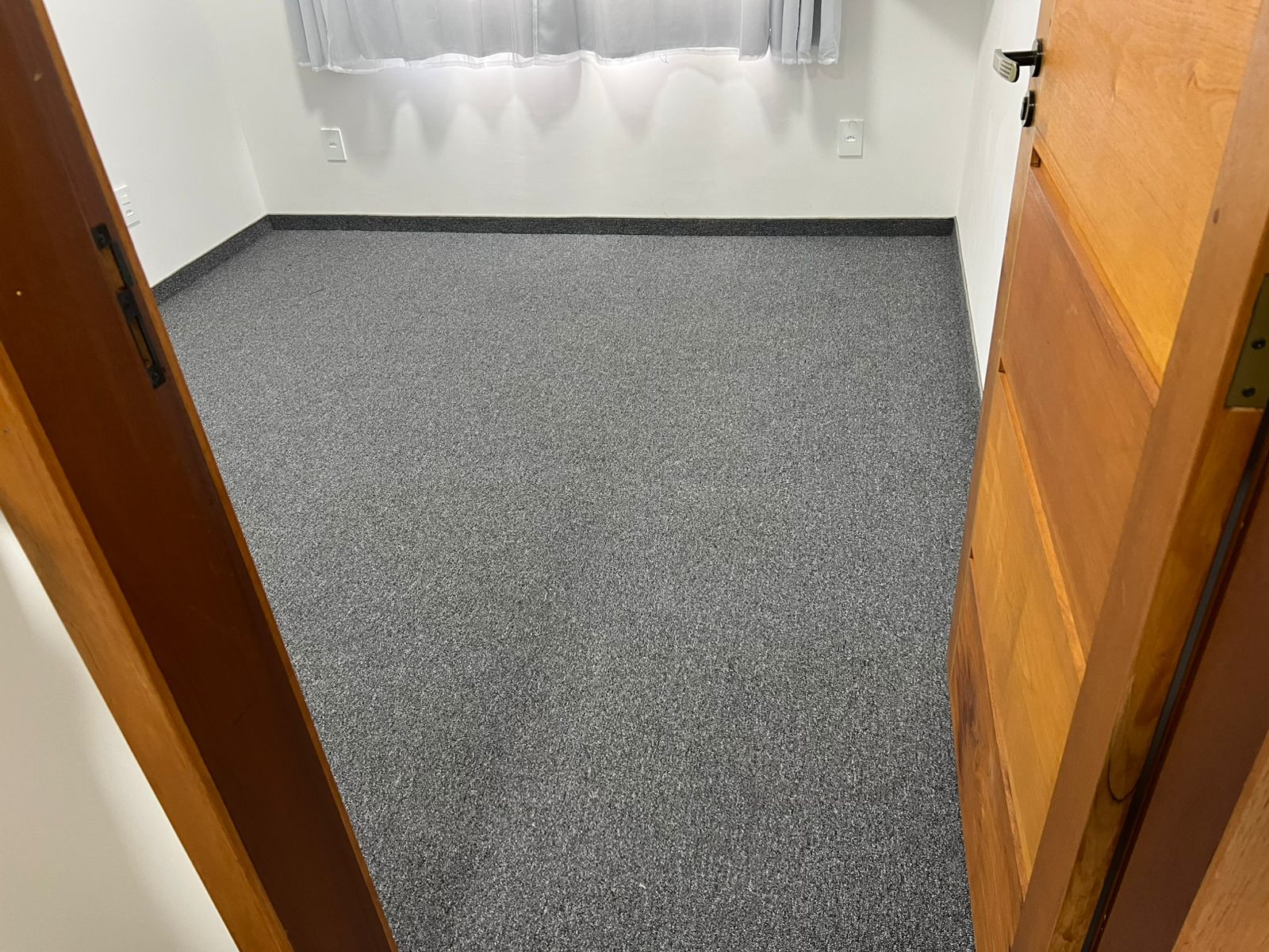 Quarto com carpete cinza instalado sob medida