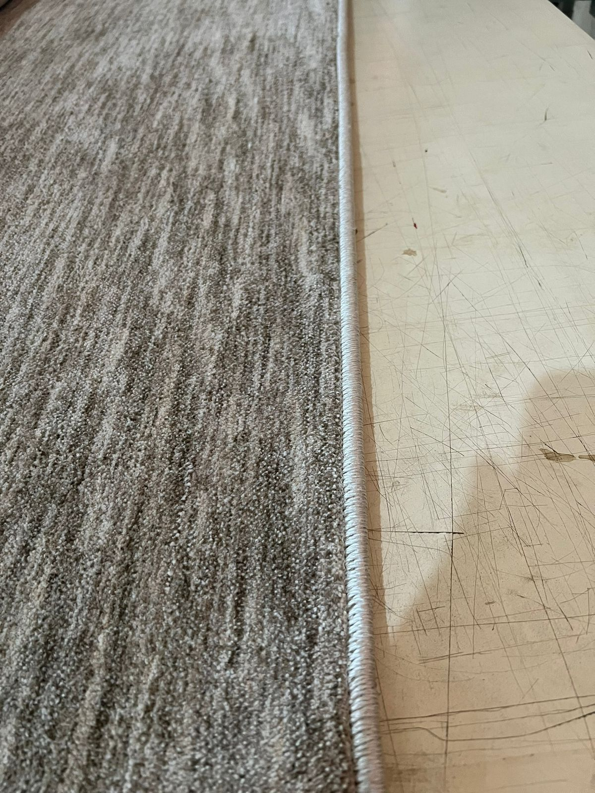 Debrum em cordão claro aplicado em carpete bege